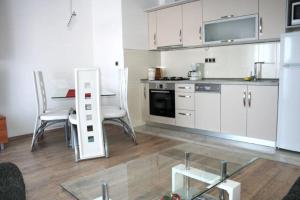 a kitchen with white appliances and a table and chairs at Lucija Apartments in Krk