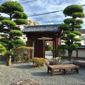 - un pavillon en bois avec un banc dans le jardin dans l'établissement まるで一国一城の主 佐藤邸, à Nichinan