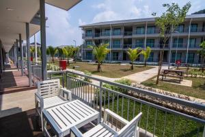 two white benches sitting in front of a building at Royale Chulan Cherating Chalet in Cherating