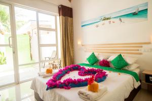 a bedroom with a large bed with flowers on it at Palm Garden in Thoddoo