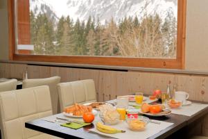 a table with food and fruit on it with a window at Hotel Edelweiss in La Fouly