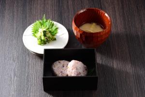 a table with a plate of broccoli and a bowl of soup at Akari no Yado Okabe in Shibukawa