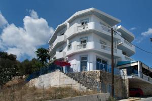 a white building with stairs in front of it at SUNSHINE APARTMENT CITY CENTER in Karpathos