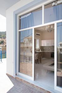 a kitchen and a living room with a large window at SUNSHINE APARTMENT CITY CENTER in Karpathos