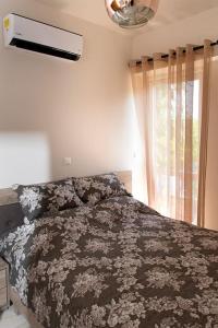 a bedroom with a bed and a window at SUNSHINE APARTMENT CITY CENTER in Karpathos