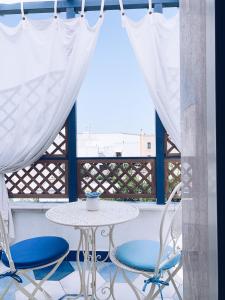 uma mesa e cadeiras em frente a uma janela em La Casa Di Ada E Gigi Vacanze em Porto Cesareo