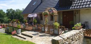 a house with a porch with chairs and plants at Zagroda AlpakoTerapii in Świeradów-Zdrój