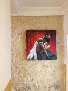 a painting of a woman in a white dress on a wall at Apartment San Carlos Alicante in Alicante