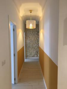 a hallway with a stone wall and a chandelier at Apartment San Carlos Alicante in Alicante