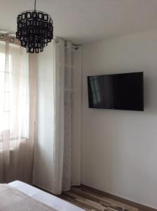 Schlafzimmer mit einem Flachbild-TV an der Wand in der Unterkunft Le Clément'Inn in Noyers-sur-Cher