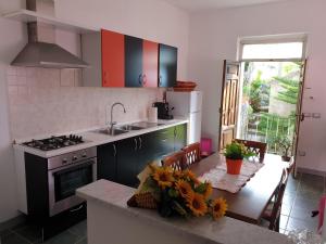 a kitchen with a table and a sink and a stove at Casa Vacanze Fontanelle in Badolato