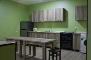 a kitchen with a table and a sink and a refrigerator at Bagration in Gori