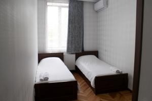 two beds in a small room with a window at Bagration in Gori