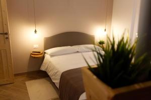 um pequeno quarto com uma cama e um vaso de plantas em La Casa Di Pinocchio em Enna