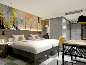 贝克西ibis Styles Bekasi Jatibening的一间带大床和书桌的卧室