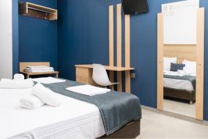 Cette chambre bleue comprend 2 lits et une chaise. dans l'établissement Aegean Blue Studios, à Neos Marmaras