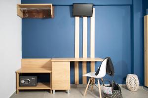 ネオス・マルマラスにあるAegean Blue Studiosの青い壁の客室で、デスクと椅子が備わります。