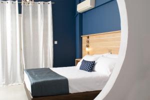 - une chambre dotée d'un lit avec un mur bleu dans l'établissement Aegean Blue Studios, à Neos Marmaras