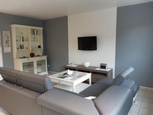 a living room with a couch and a table at Cosy maison 3 chambres Honfleur jardin, parking privé et jacuzzi in Honfleur