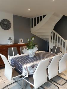 uma sala de jantar com uma mesa e cadeiras brancas em Cosy Maison Honfleur em Honfleur