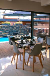 uma sala de jantar com mesas e cadeiras e uma piscina em Hotel AT Hatfield Apartments em Pretoria
