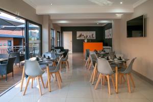a dining room with tables and chairs in a restaurant at Hotel AT Hatfield Apartments in Pretoria