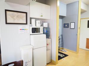 uma cozinha com um frigorífico e um micro-ondas. em Holiday Homes TSUBOYA 505 em Naha