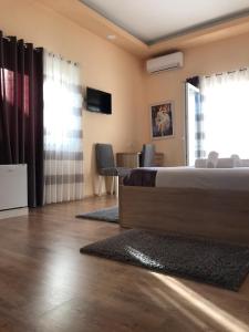 1 dormitorio con 1 cama, mesa y sillas en Hotel Floga, en Shkodër