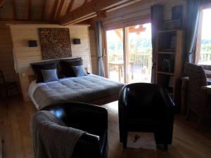 a bedroom with a bed and two chairs at Aura Cabana - Cabane spa perchée à 6 m de haut in Saint-André-dʼOlérargues