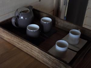 a tray with three cups and a tea pot on it at Aura Cabana - Cabane spa perchée à 6 m de haut in Saint-André-dʼOlérargues +6 photos
