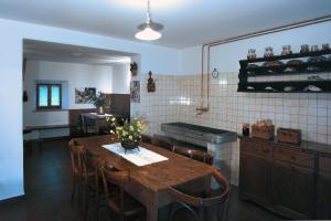 a kitchen with a wooden table and chairs and a counter at Albergo Diffuso Comeglians in Comeglians