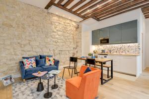 sala de estar con sofá azul y pared de piedra en Sweet Inn - Clery, en París