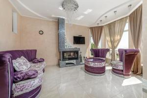 チョロノモスクにあるVIP house near seaの紫色の家具と暖炉付きのリビングルーム