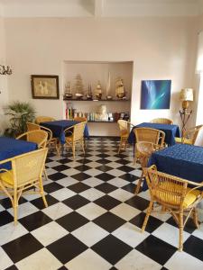 a restaurant with tables and chairs and a checkered floor at Albergo Lungomare in Bonassola