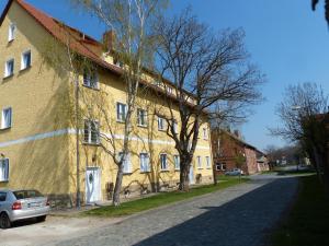 a yellow building on the side of a street at Ferienwohnung mit Brockenblick in Langenstein