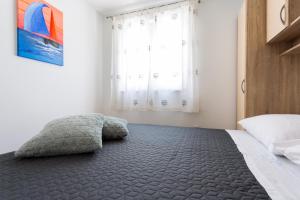 a bedroom with a bed with a pillow on the floor at Apartments Lidija - sea view apartment with exclusive right of using hot tub or split level apartment with exclusive right of using pool in Podstrana