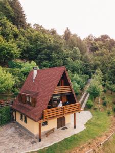 a house with a brown roof with a man standing outside at Chalet Alma in Frabosa Sottana