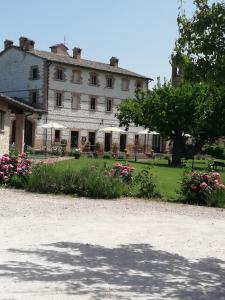 un grand bâtiment avec des fleurs devant lui dans l'établissement Parco Ducale Country House, à Urbania