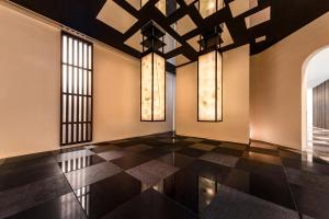 a room with a black and white tile floor and windows at Hotel Hanshin Annex Osaka in Osaka