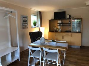 Habitación con mesa, sillas y cocina. en Aparthotel Stibbe, en Horn-Bad Meinberg
