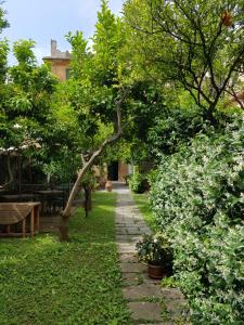 a garden with trees and a stone path at Albergo Lungomare in Bonassola