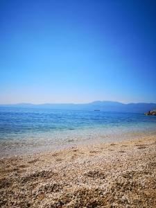 een strand met de oceaan en bergen op de achtergrond bij Marica in Rijeka