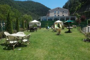 eine Liegewiese mit Tischen und Stühlen vor einem Gebäude in der Unterkunft Sarot Termal Park Resort & Spa - Halal Hotel in Bolu