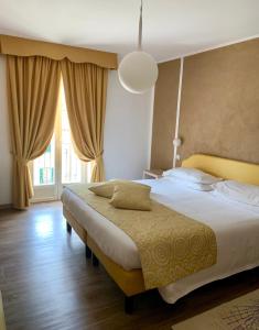 sypialnia z łóżkiem i dużym oknem w obiekcie Hotel Centrale w mieście San Pellegrino Terme