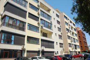a tall building with cars parked in front of it at Apartament Mamaia in Mamaia