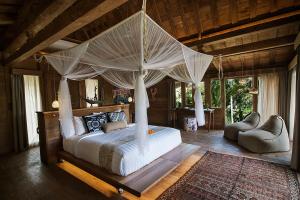 
a bedroom with a bed and a canopy canopy at Blue Karma Dijiwa Ubud in Ubud
