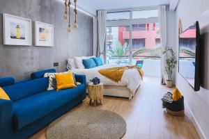 sala de estar con sofá azul y cama en Loft Ciudad del Mar Gran Canaria, en Las Palmas de Gran Canaria