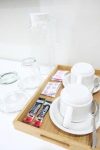 a wooden tray with cups and dishes on a table at Hampton Suites in Davao City