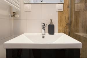 CR Uroczy Apartament w Centrum Nowy Świat 18 في بياويستوك: حمام مع حوض أبيض وموزع صابون +38 صورة