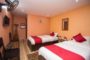 a hotel room with two beds and orange walls at Bandipur Eco Hotel in Bandīpur